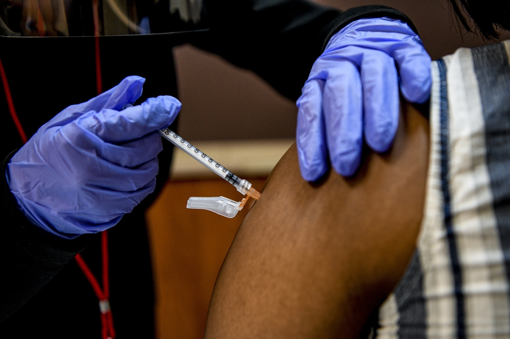 A health care worker administers a COVID-19 vaccine in Washington, Feb. 4, 2021. (Kenny Holston/The New York Times)