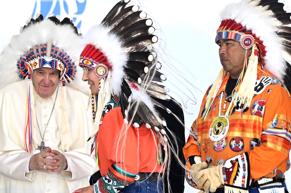 Pope Francis wears a headdress presented to him by Indigenous leaders at Muskwa Park in Maskwacis, Alberta, Canada, on Monday. -- AFP