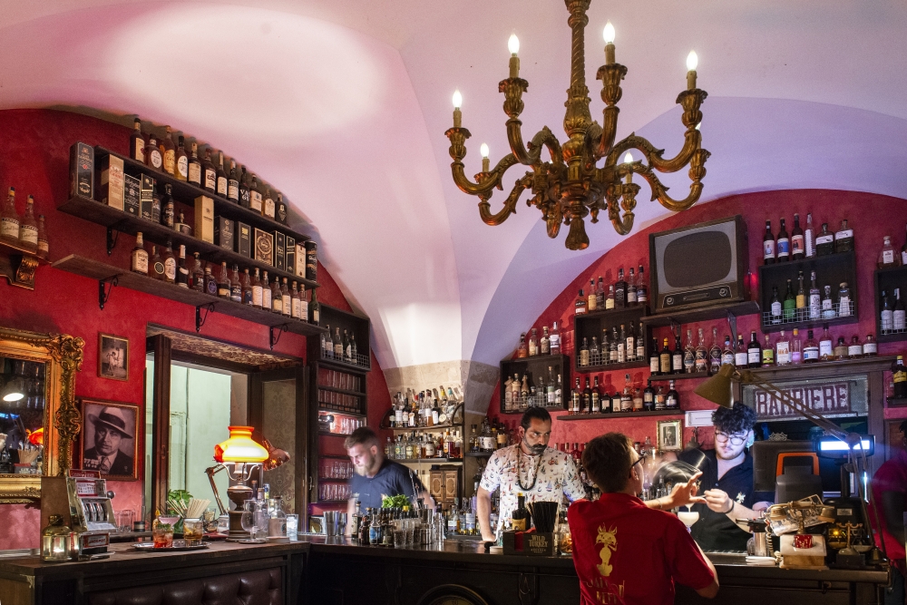Members of the staff make artisanal cocktails at Saloon Keeper 1933, a speakeasy-style bar in the historic center of Lecce, Italy, July 14, 2022. (Susan Wright/The New York Times)