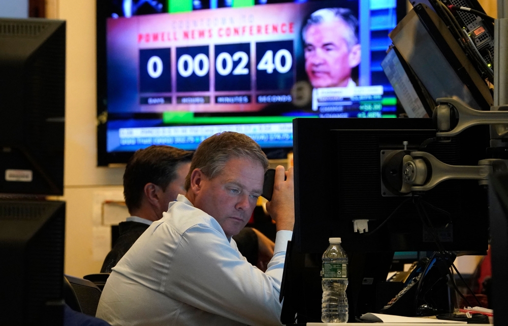 A person on the floor of the New York Stock Exchange (NYSE) watches TV screens. - AFP 