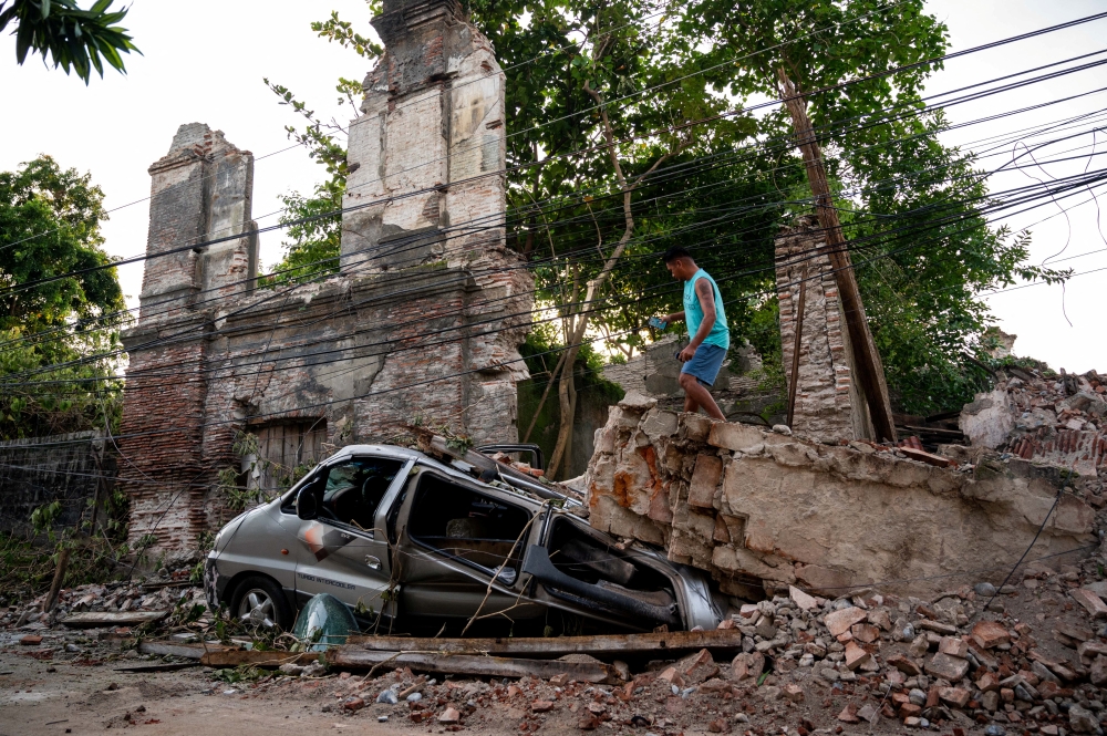 A man inspects a damaged car in the aftermath of an earthquake in Vigan City, Ilocos Sur, Philippines, on Thursday. - Reuters