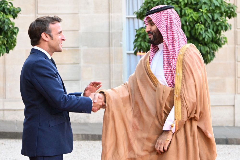 France's President Emmanuel Macron greets Saudi Crown Prince Mohammed bin Salman as he arrives at presidential Elysee Palace in Paris on Thursday. - AFP