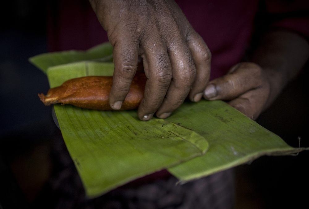 A roadside vendor serves food on banana leaves, a traditional way of plating or wrapping that is gaining popularity in the face of a ban on disposable plastics, in Chennai, India, July 7, 2022. (Anindito Mukherjee/The New York Times)