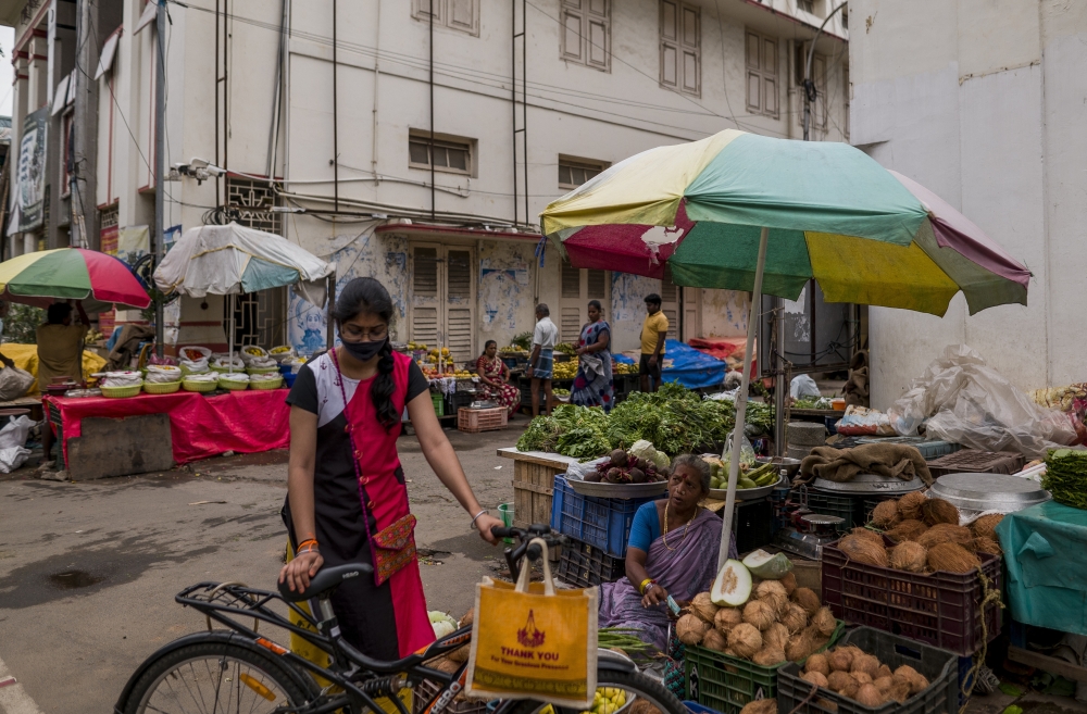 A shopper with her own reusable bag at a produce market in Chennai, India, July 8, 2022. (Anindito Mukherjee/The New York Times)