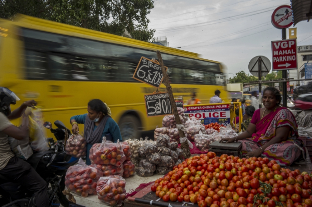Produce hawker Amul Vasudevan, who was fined repeatedly for using throwaway bags, along a busy road in Chennai, India, July 7, 2022. (Anindito Mukherjee/The New York Times)