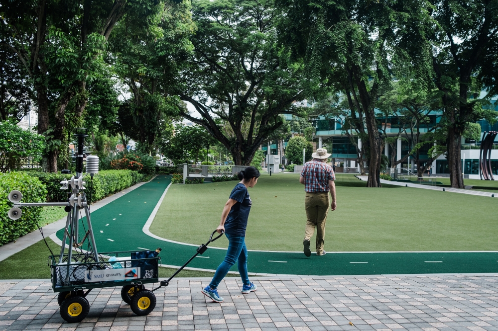 Rachel Pek, a research assistant, pulls Smarty, a device that tracks radiation from the atmosphere, surfaces and wind, during a survey in Singapore, July 5, 2022. (Gabriela Bhaskar/The New York Times)