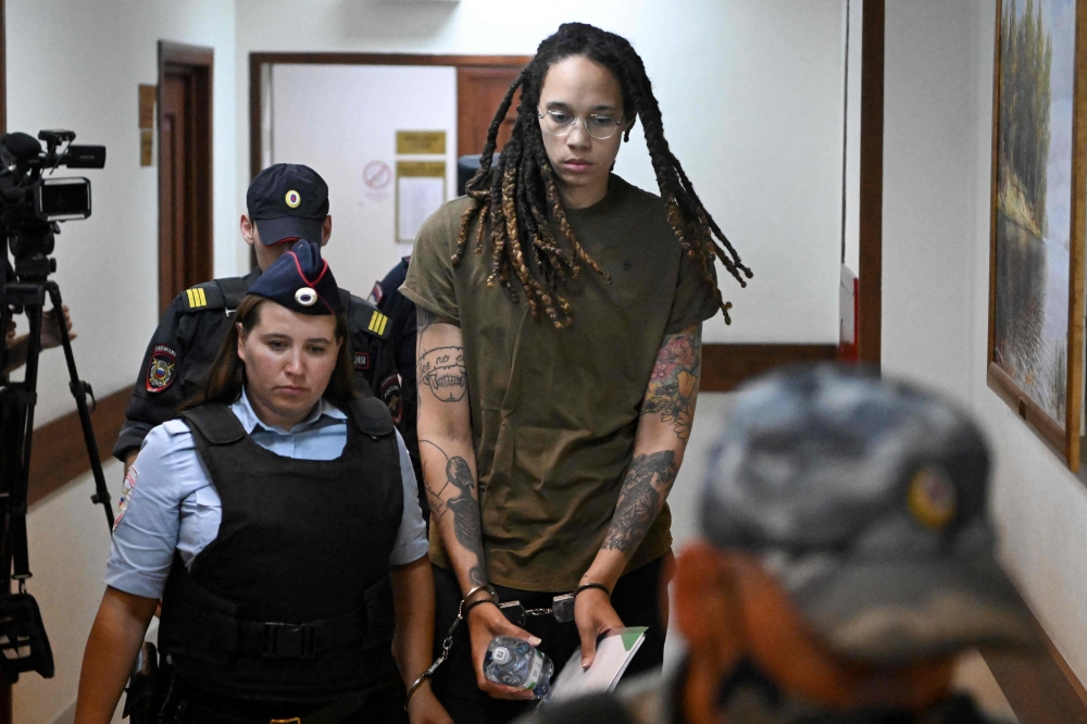 US basketball player Brittney Griner (C) is escorted by police before a hearing during her trial on charges of drug smuggling, in Khimki, outside Moscow on Tuesday. -- AFP