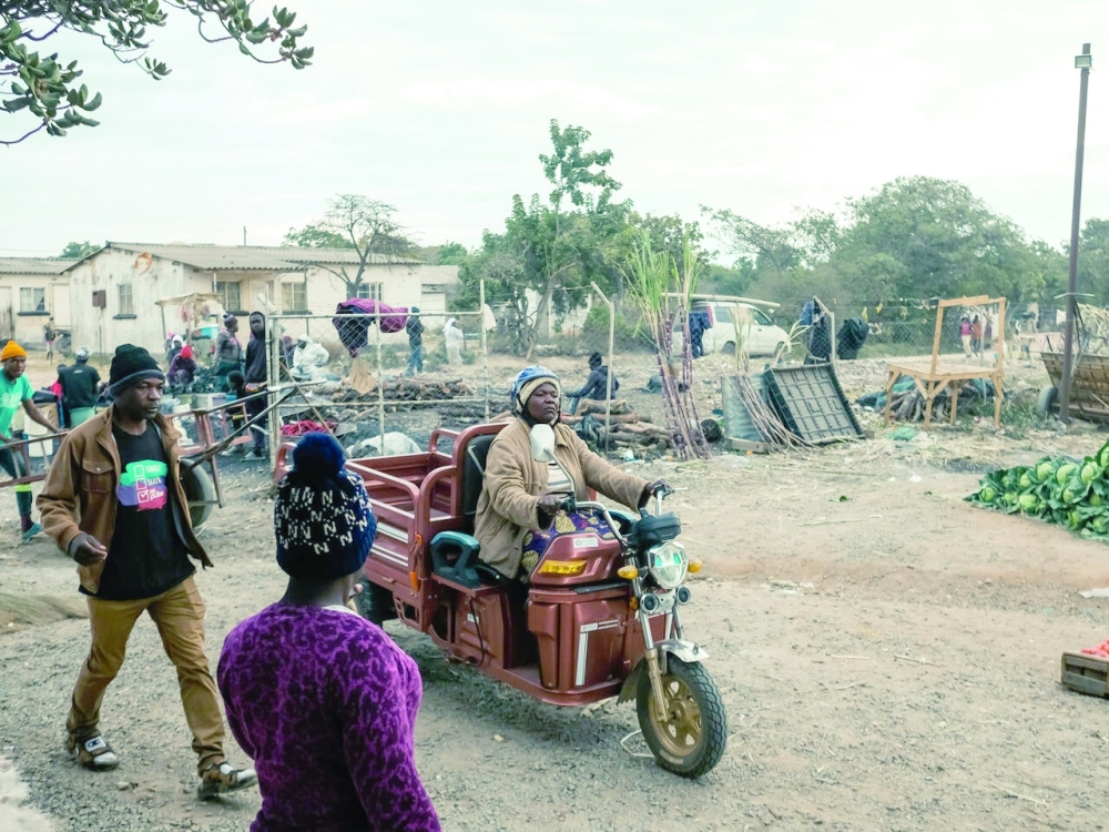 Danai Bvochora a poultry farmer arrives at market on her renewable energy electrical tricycle which is designed for a rural off road environment such as her home in Domboshawa, July 20 2022. The tricycle has been a boost to her egg business as she no longer travels long distances to market carrying heavy loads on her head or paying exhobitant rates to transport her crates of eggs.