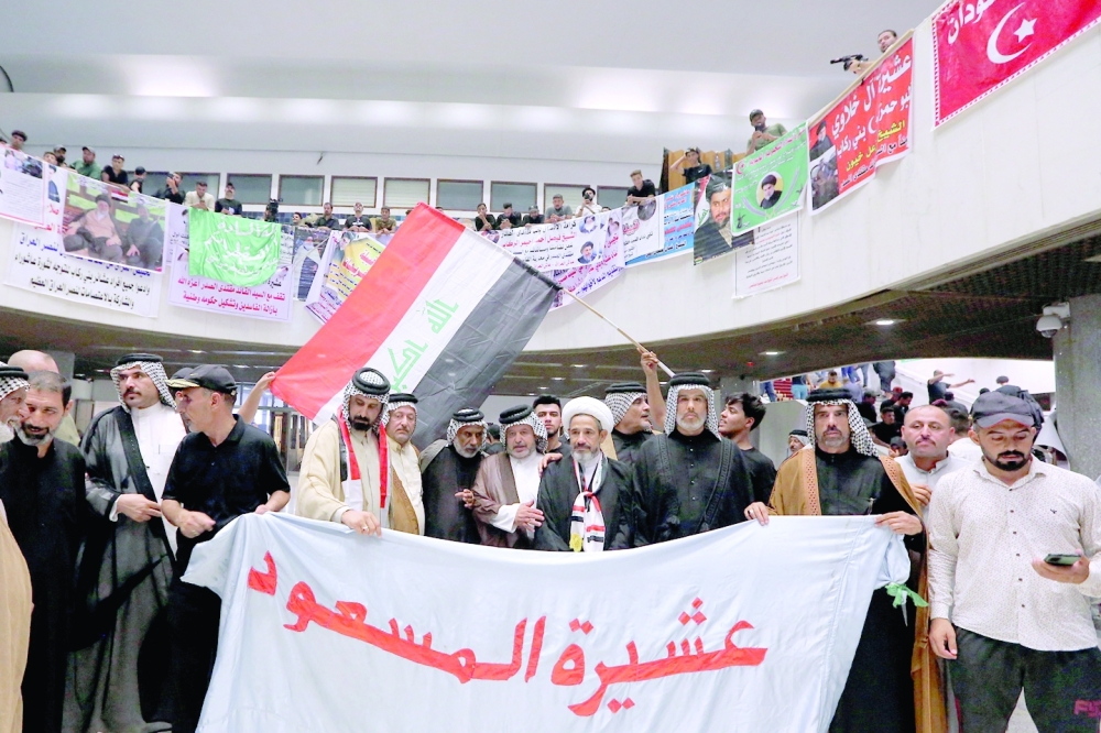 Supporters of Moqtada Sadr, protesting against a rival bloc's nomination for prime minister, raise a banner bearing the name of one of the tribal clans (Masoud Clan) at their sit-in inside Iraq's parliament headquarters in Baghdad's high-security Green Zone, on Wednesday. -- AFP