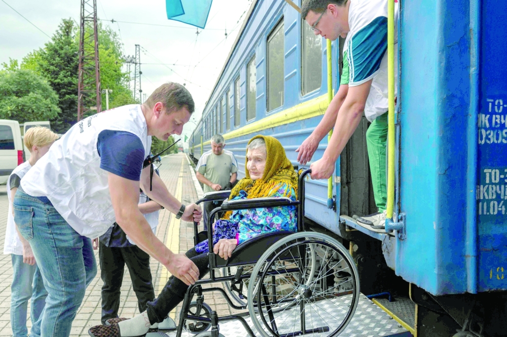 An elderly woman on a wheelchair is helped to board on a train used by "Doctors Without Borders" NGO to evacuate people from Donetsk region, in the train station of Pokrovsk, eastern Ukraine. -- AFP