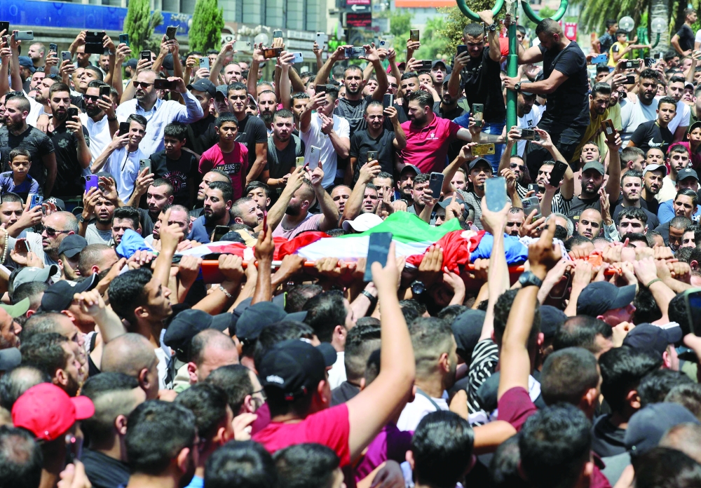 Mourners carry the body of Palestinian fighter of the Al Aqsa Martyrs' Brigade Hussein Taha, who was killed in an Israeli raid, during a funeral procession in the West Bank city of Nablus on Tuesday. - AFP