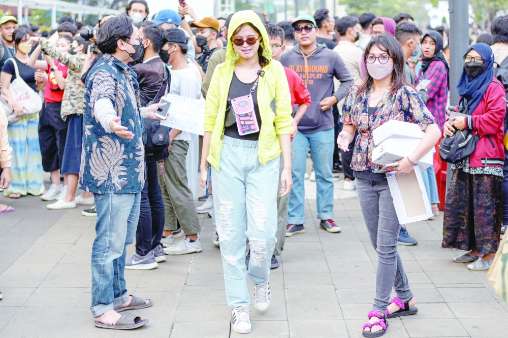 This picture taken on July 22, 2022 shows Indonesian youths presenting self-styled fashion creations by a pedestrian crossing turned catwalk, part of a gathering in recent weeks dubbed "Citayam Fashion Week", in Jakarta.  The crowd of fashionistas turning one of Jakarta's main commuter hubs into a makeshift catwalk have courted controversy in Indonesia's traffic-clogged capital, but their festival of style has become a site for free expression.
 - TO GO WITH AFP STORY INDONESIA-FASHION,FOCUS BY DESSY SAGITA 
 (Photo by BAY ISMOYO / AFP) / TO GO WITH AFP STORY INDONESIA-FASHION,FOCUS BY DESSY SAGITA 

