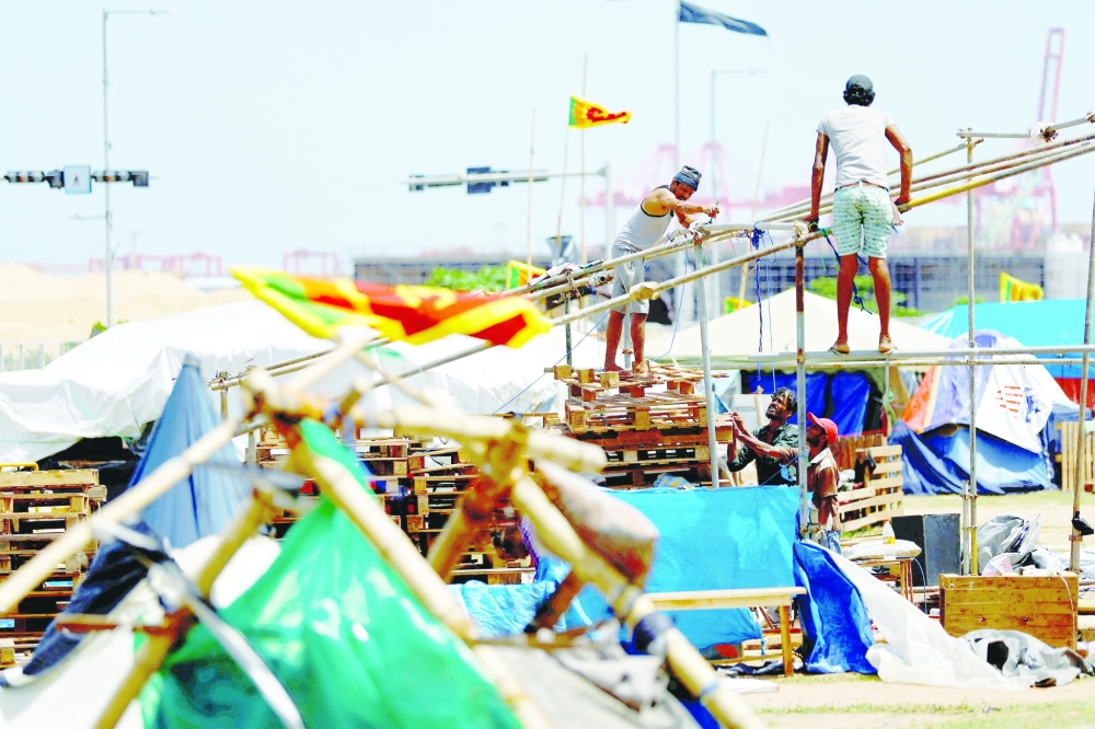 Protesters dismantle their tents from a seafront tent camp that became the focal point of months-long nationwide demonstrations, amid the country's economic crisis, in Colombo, on Wednesday. -- Reuters