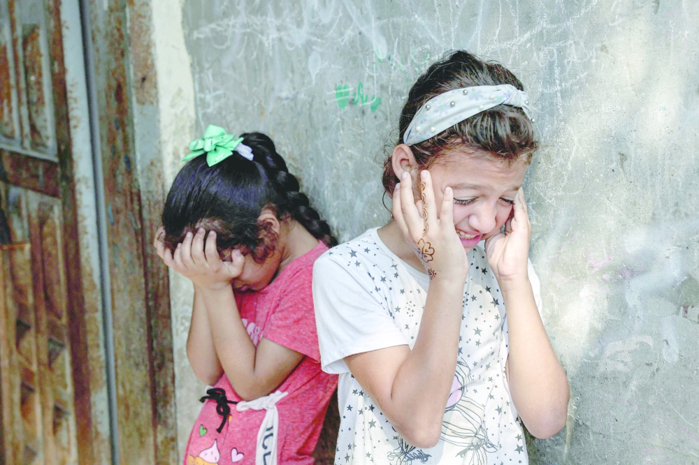 Friends react during the funeral of Palestinian child Lian al Shaer, after she succumbed to her injuries sustained in last week's Israeli air strikes, in Khan Younis in the southern Gaza Strip, on Thursday. - AFP