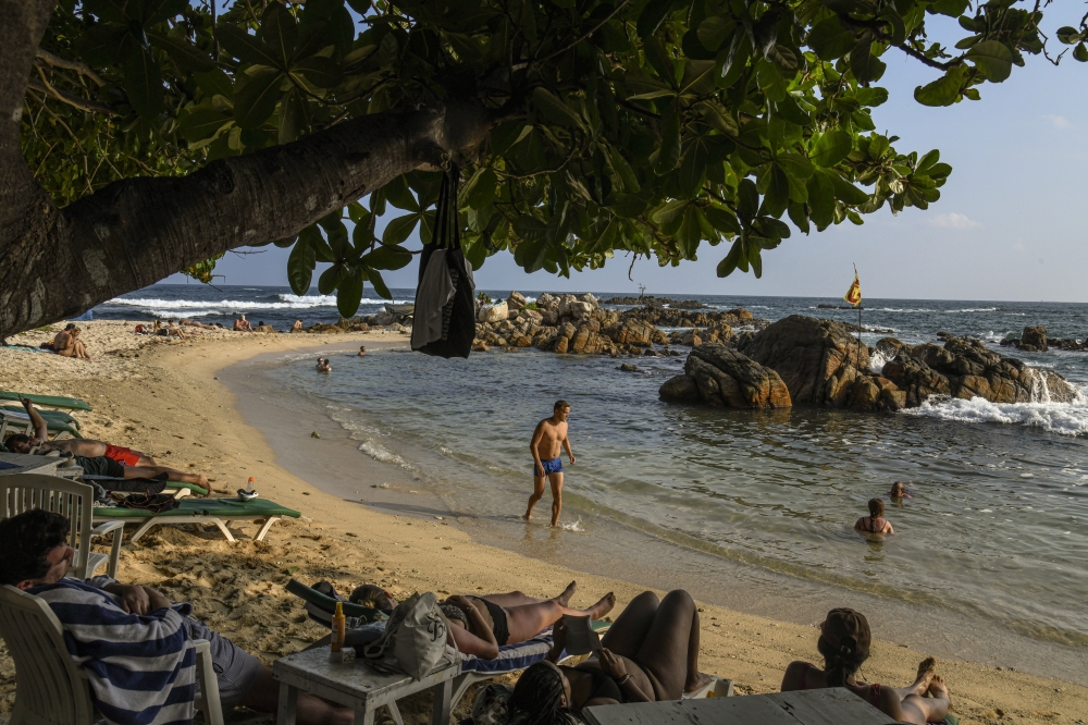 A Tourist on a beach at Mirissa, Sri Lanka, on March 9, 2022. (Atul Loke/The New York Times)