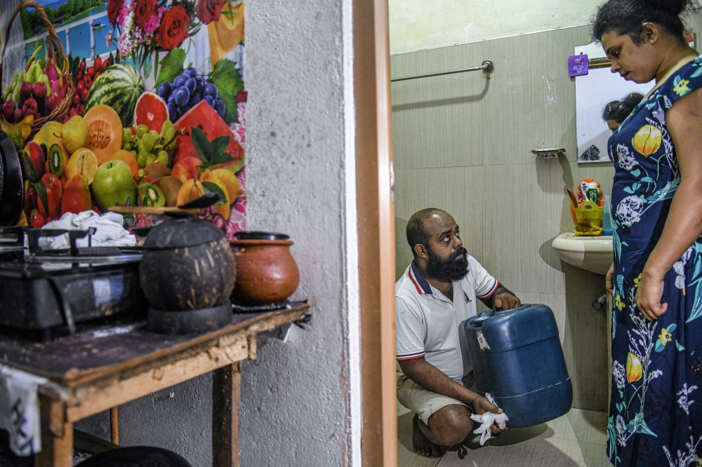 Mangla Srinath checks the fuel container he keeps in his bathroom, in Colombo, Sri Lanka, on July 19, 2022. (Atul Loke/The New York Times)