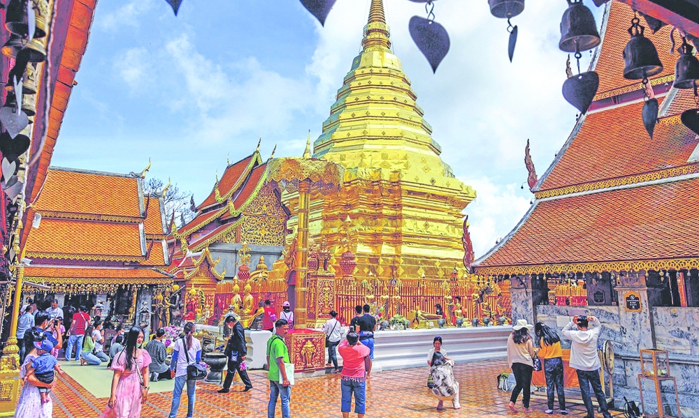Visitors take pictures of the gold plated stupa at Wat Phra That Doi Suthep Buddhist temple in Chiang Mai. — AFP