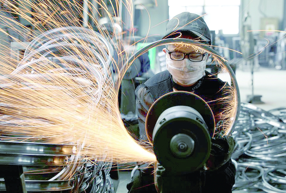 A worker welds a bicycle steel rim at a factory manufacturing sports equipment in Hangzhou, Zhejiang province, China. — Reuters