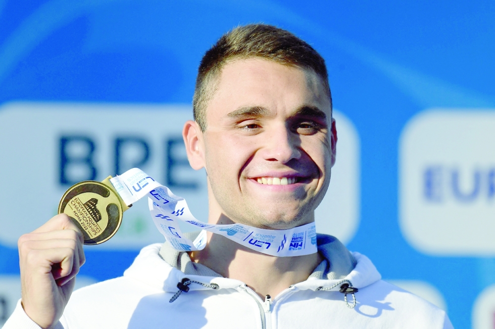 Gold medallist Hungary's Kristof Milak poses on the podium after winning the Men's 100m butterfly final on August 14, 2022 during the LEN European Aquatics Championships in Rome. (Photo by Filippo MONTEFORTE / AFP)

