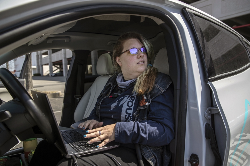 Nicole Larsen downloads diagnostic information to her laptop while testing a charging station in Valley Stream, N.Y., on April 14, 2022. (Victor J. Blue/The New York Times)