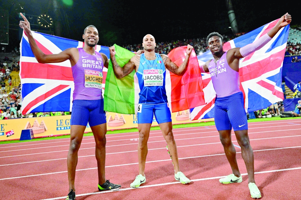 Britain's Zharnel Hugnes (L, silver), Italy's Lamont Marcell Jacobs (C, gold) and Britain's Jeremiah Azu (bronze) pose after the men's 100m final during the European Athletics Championships at the Olympic Stadium in Munich, southern Germany on August 16, 2022. (Photo by ANDREJ ISAKOVIC / AFP)

