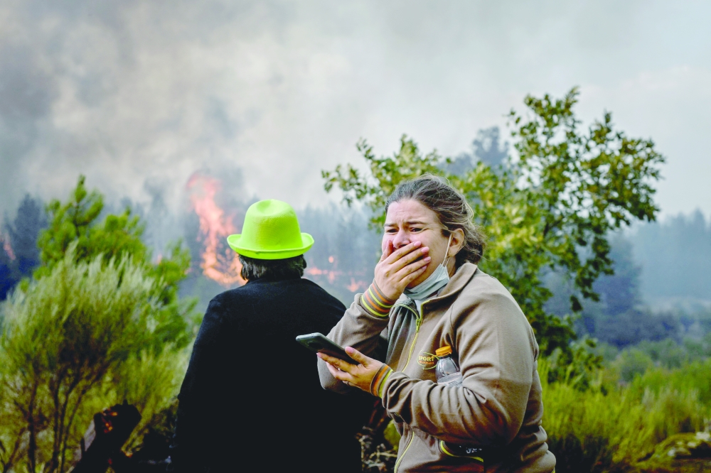 A local reacts to watching a wildfire advancing in Orjais, Covilha council in central Portugal on Wednesday. — AFP