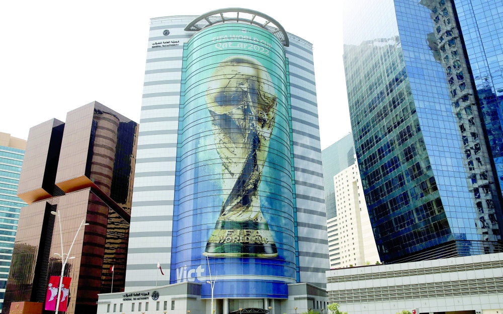 TOPSHOT - An image of the FIFA 2022 World Cup trophy adorns a building in the Qatari capital Doha on August 16, 2022.  (Photo by Mustafa ABUMUNES / AFP)

