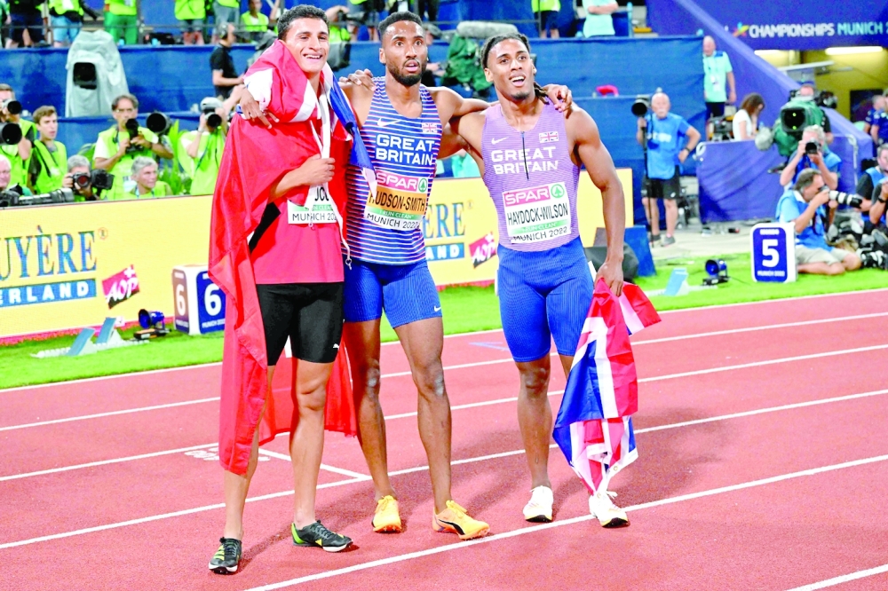 Britain's Matthew Hudson-Smith (C) celebrates winning gold with silver medalist Switzerland's Ricky Petrucciani (L) and bronze medalist Britain's Alex Haydock-Wilson in the men's 400m final during the European Athletics Championships at the Olympic Stadium in Munich, southern Germany on August 17, 2022. (Photo by ANDREJ ISAKOVIC / AFP)

