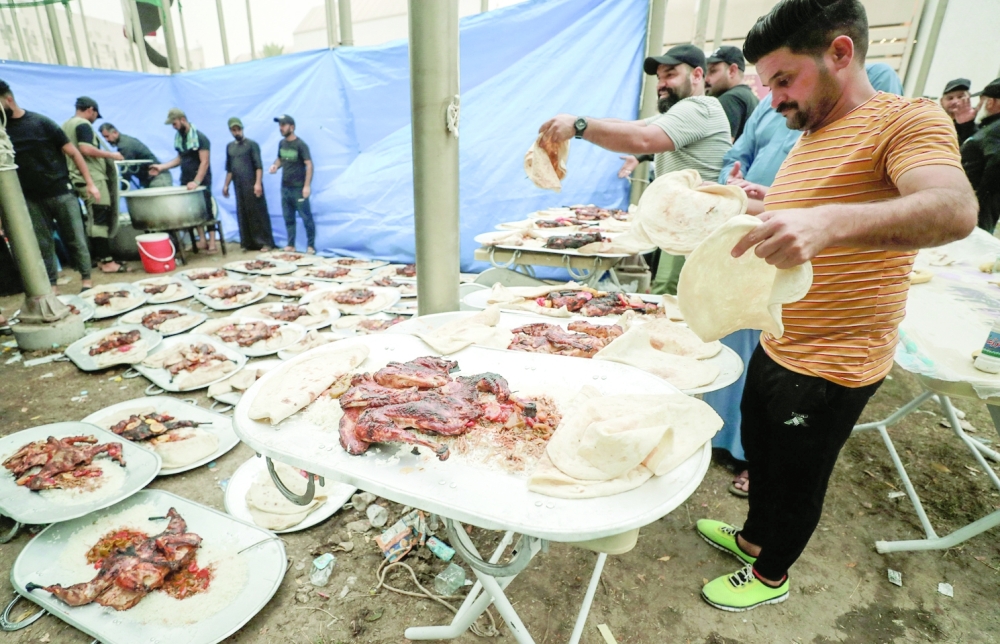 Iraqi volunteers prepare food portions for supporters of cleric Moqtada Sadr, outside the Iraqi parliament building in the Green Zone of Baghdad. - AFP 