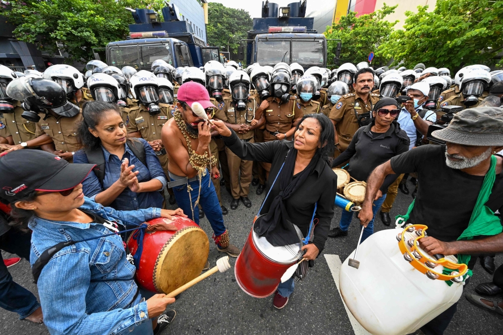 Policemen try to block Sri Lankan university students during a demonstration in Colombo on August 18, 2022. 