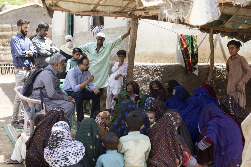 Dr. Jai Das speaks with residents, hoping to convince them to get the polio vaccine, in the neighborhood of Rheri Goth in Karachi, Pakistan, April 25, 2022.  (Khaula Jamil/The New York Times)