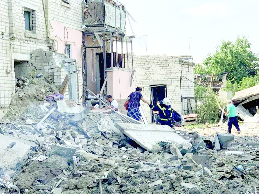 A rescuer helps a woman to be evacuated from a residential building damaged by a Russian missile strike in Voznesensk, Mykolaiv region, Ukraine on Saturday. - Reuters 