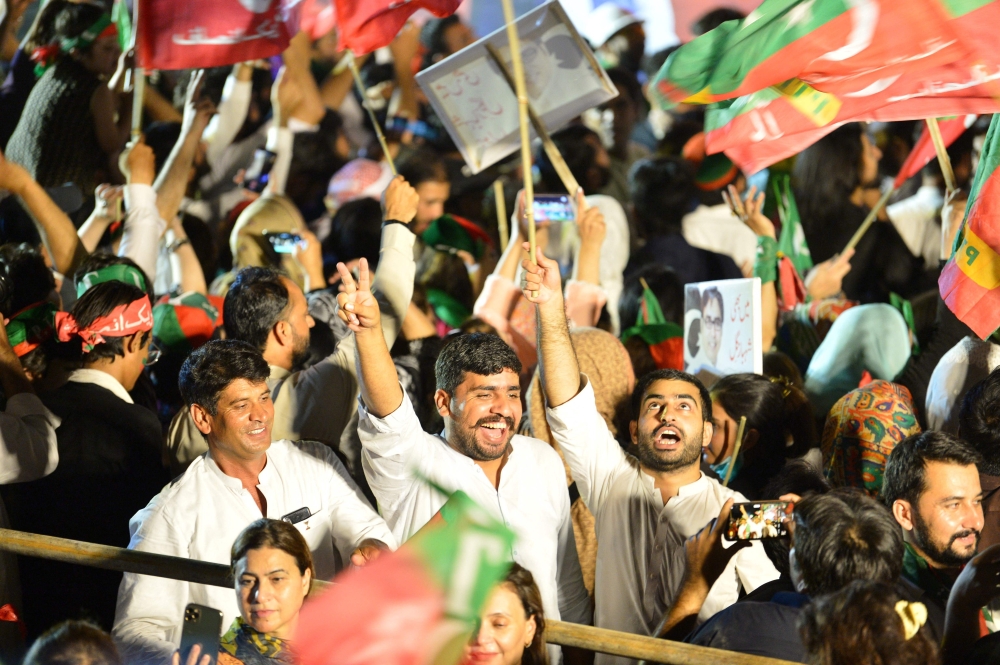 Supporters of Pakistan's former Prime Minister and leader of the Pakistan Tehreek-e-Insaf party (PTI) Imran Khan, wave flags during an anti-government protest rally in Islamabad on August 20, 2022.