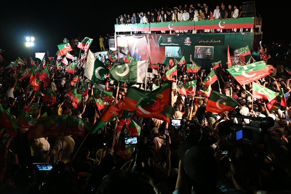 Supporters of Pakistan's former Prime Minister and leader of the Pakistan Tehreek-e-Insaf party (PTI) Imran Khan, wave flags during an anti-government protest rally in Islamabad on August 20, 2022.