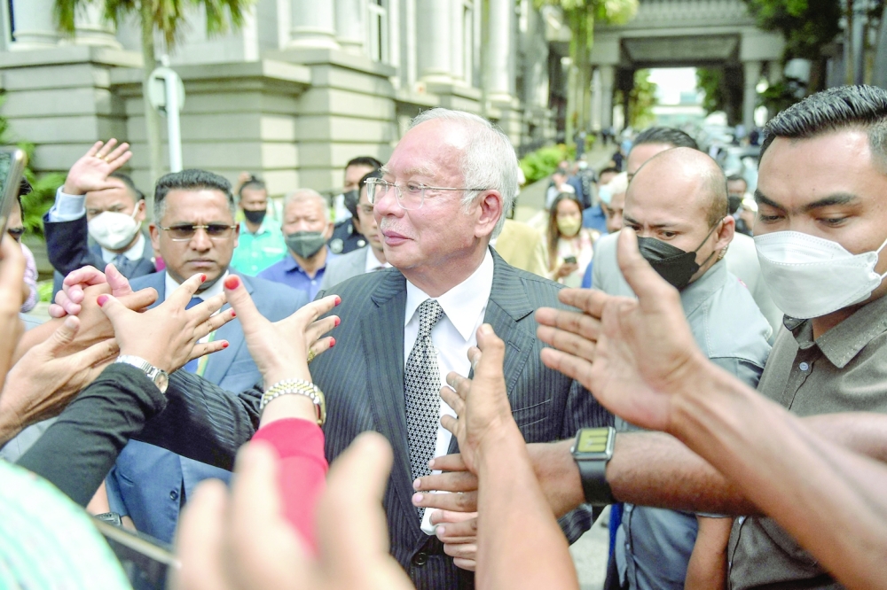 Najib Razak greets supporters as he walks out during a break in the trial during an appeal against his corruption conviction over the 1MDB financial scandal, at the federal court in Putrajaya, on Tuesday. - AFP