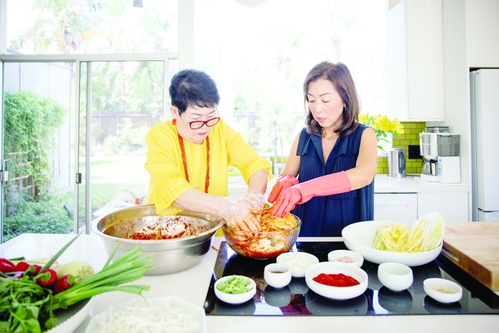 Lauryn Chun, right, the founder of Mother-in-Law’s Kimchi, cooks with her mother, left, at their home in Orange, Calif. on Aug. 16, 2022. (Tanveer Badal/The New York Times)