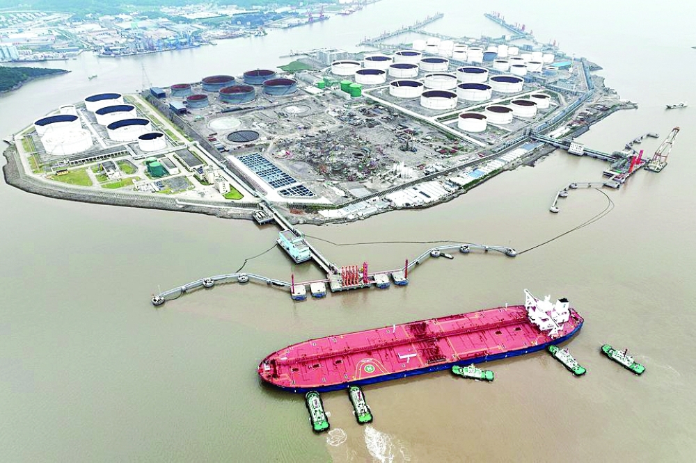 An aerial view shows tugboats helping a crude oil tanker to berth at an oil terminal, off Waidiao Island in Zhoushan, Zhejiang province, China. — Reuters