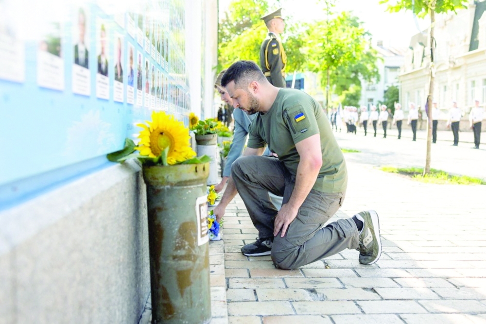 Ukraine's President Volodymyr Zelensky and his wife Olena lay flowers at the Memory Wall of Fallen Defenders of Ukraine in Kyiv. - Reuters