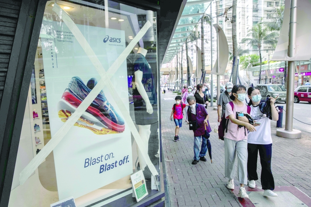Shops tape up their windows in Hong Kong on Wednesday as an approaching powerful typhoon prompts the city to issue its third highest storm warning. - AFP