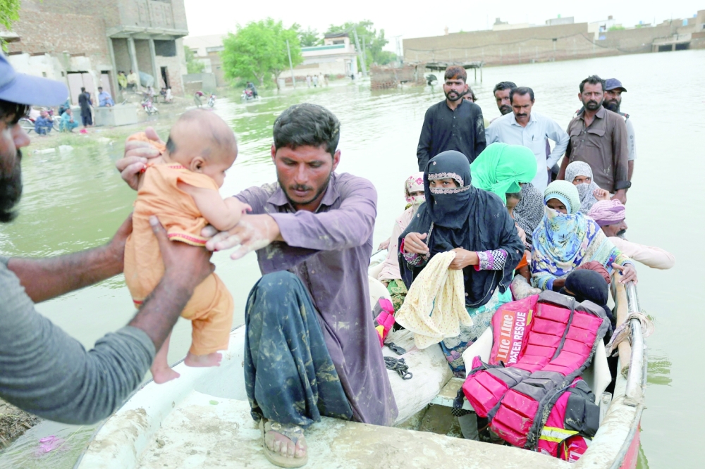 Residents arrive in a boat to a safer place after being evacuated following heavy monsoon rainfall in the flood affected area of Rajanpur district in Punjab province on Wednesday. - AFP