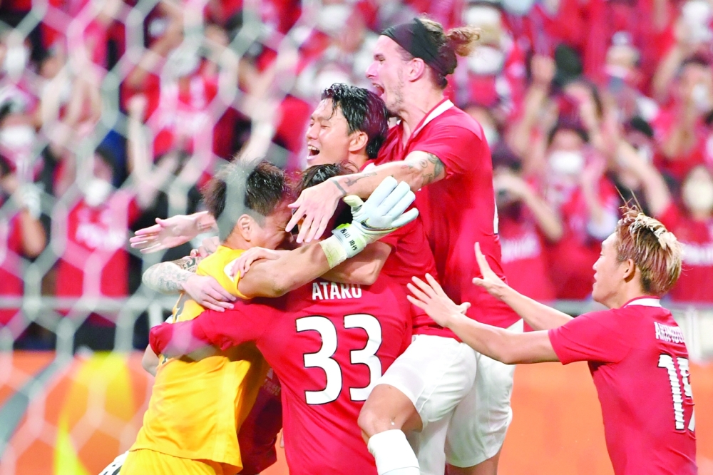 Urawa Reds' players including Japanese goalkeeper Shusaku Nishikawa celebrate after winning the AFC Champions League semi-final football match between South Korea's Jeonbuk Hyundai Motors FC and Japan's Urawa Red Diamonds in Saitama, on August 25, 2022.  (Photo by Kazuhiro NOGI / AFP)

