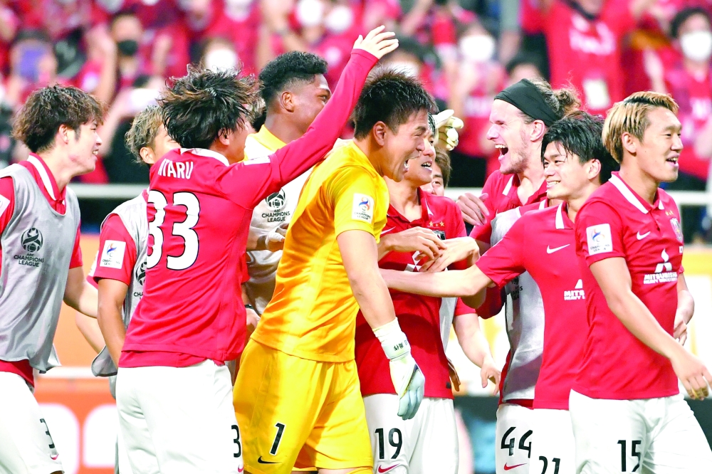 Urawa Reds' players including Japanese goalkeeper Shusaku Nishikawa celebrate after winning the AFC Champions League semi-final football match between South Korea's Jeonbuk Hyundai Motors FC and Japan's Urawa Red Diamonds in Saitama, on August 25, 2022.  (Photo by Kazuhiro NOGI / AFP)

