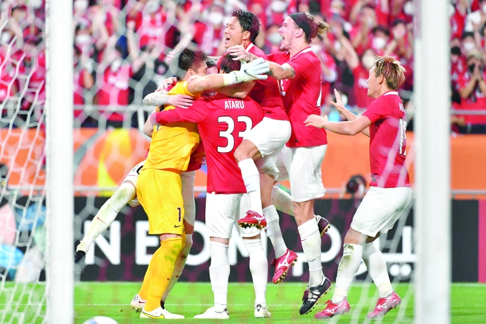 Urawa Reds' players including Japanese goalkeeper Shusaku Nishikawa celebrate after winning the AFC Champions League semi-final football match between South Korea's Jeonbuk Hyundai Motors FC and Japan's Urawa Red Diamonds in Saitama, on August 25, 2022.  (Photo by Kazuhiro NOGI / AFP)

