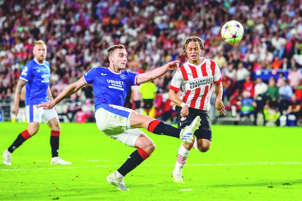 TOPSHOT - Glasgow Rangers' Croatian defender Borna Barisic (2ndL) fights for the ball with PSV's Dutch midfielder Xavi Simons (R) during the UEFA Champions League play-off football match between PSV Eindhoven and Rangers FC at the Phillips stadium in Eindhoven on August 24, 2022.  - Netherlands OUT
 (Photo by Olaf Kraak / ANP / AFP)

