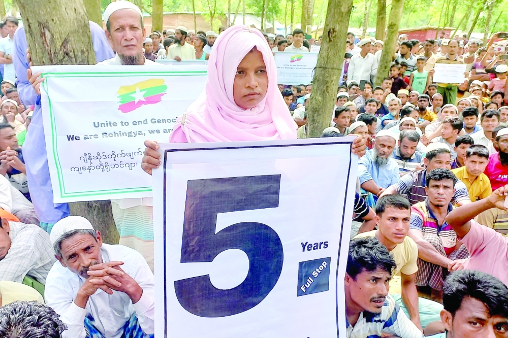 Rohingya refugees hold placards as they gather at the Kutupalong Refugee Camp to mark the fifth anniversary of their fleeing from neighbouring Myanmar to escape a military crackdown in 2017, in Cox's Bazar, Bangladesh, on Thursday. - Reuters