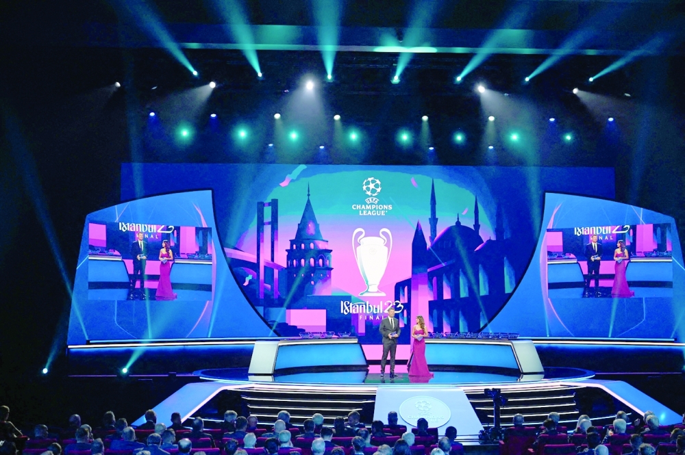 UEFA Managing Director of Communications Pedro Pinto (L) looks on next to British journalist Reshmin Chowdhury on stage during the draw ceremony for the 2022-2023 UEFA Champions League football tournament in Istanbul on August 25, 2022. (Photo by OZAN KOSE / AFP)

