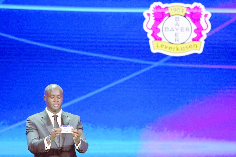 Former Ivorian midfielder Yaya Toure shows the paper slip of Germany's Bayern Leverkusen during the draw for the UEFA Champions League football tournament 2022-2023 in Istanbul on August 25, 2022. (Photo by OZAN KOSE / AFP)

