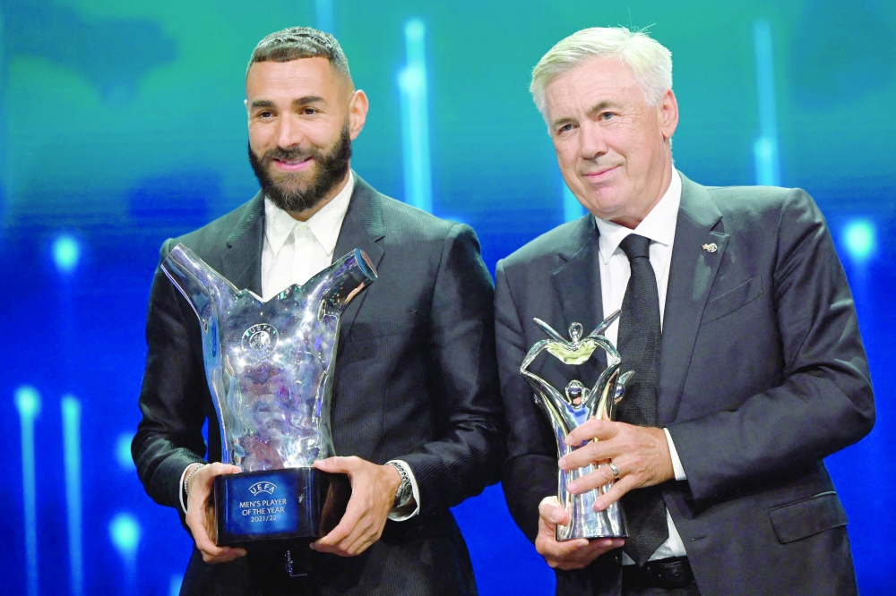 TOPSHOT - Real Madrid's French forward Karim Benzema poses with his "UEFA Men's Player of the Year 2021/2022 Award" next to Real Madrid's Italian coach Carlo Ancelotti posing with his "Coach of the Year Award" in Istanbul on August 25, 2022, after the 2022/2023 Champions League group stage draw. (Photo by OZAN KOSE / AFP)

