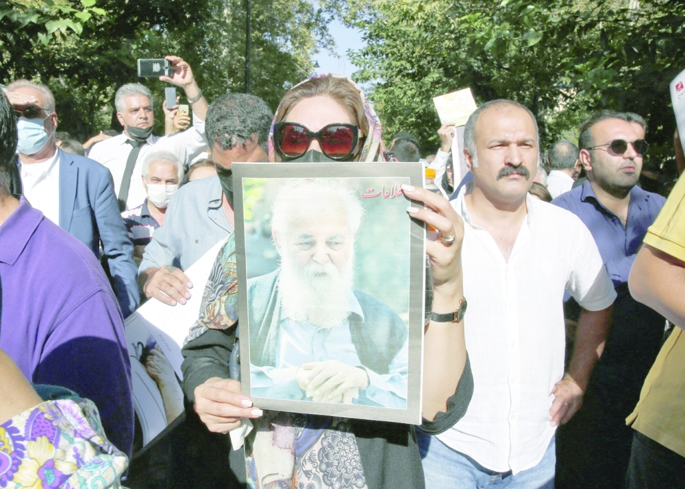 Iranians attend a funeral ceremony for Hushang Ebtehaj outside the Vahdat hall in Tehran, on Friday. - AFP