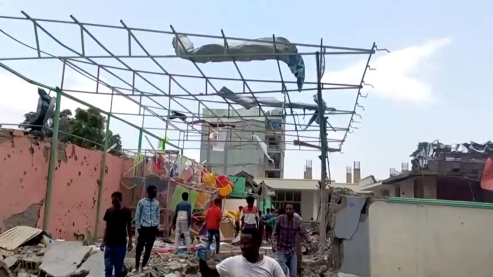 People inspect a damaged playground following an air strike in Mekelle, the capital of Ethiopia's northern Tigray region, on August 26, 2022, in this still image taken from video.